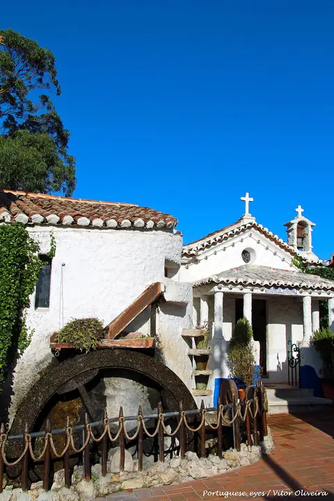 Casas brancas com roda de moinho e pequena capela na Aldeia Típica de José Franco, Sobreiro