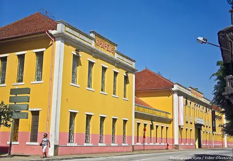 Fachada amarela e rosa do Museu da Chapelaria em São João da Madeira, com letreiro "Chapéus"