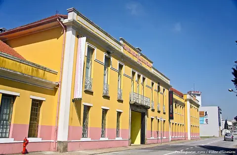 Fachada amarela e rosa do Museu da Chapelaria, em São João da Madeira, vista da rua.