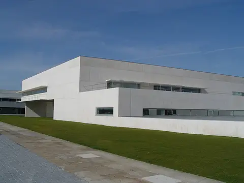 Edifício moderno de betão branco da Biblioteca Municipal de Viana do Castelo, com relvado em frente.