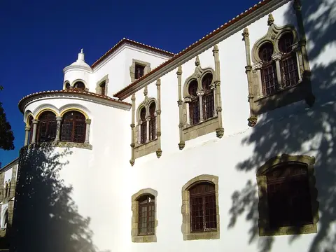 Fachada branca do Palácio de Dom Manuel, em Évora, com janelas geminadas de estilo manuelino