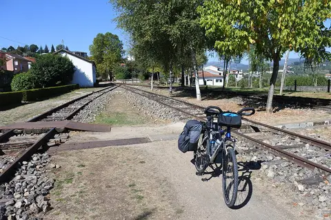 Bicicleta de cicloturismo junto às linhas férreas antigas da estação de Arco de Baúlhe