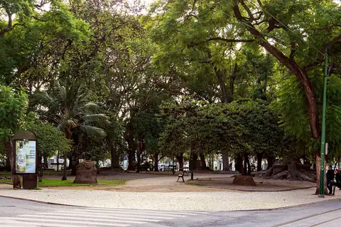 Jardim de Santos com árvores frondosas, bancos e passeio em calçada portuguesa