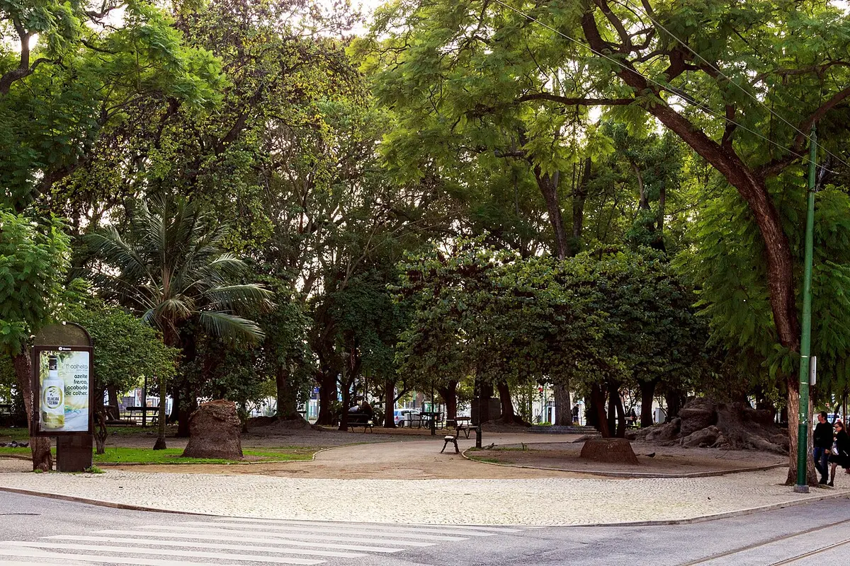 Jardim de Santos com árvores frondosas, bancos e passeio em calçada portuguesa