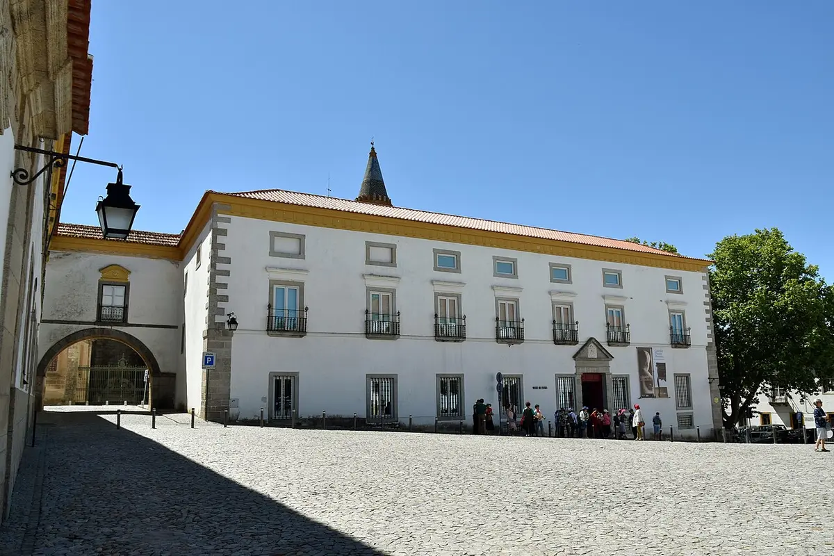 Fachada branca do Museu Nacional Frei Manuel do Cenáculo, em Évora, vista do largo calcetado.