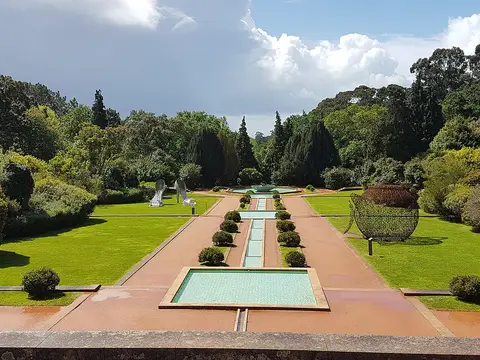 Jardins de Serralves com espelhos de água alinhados, relvados, buxos e esculturas ao fundo