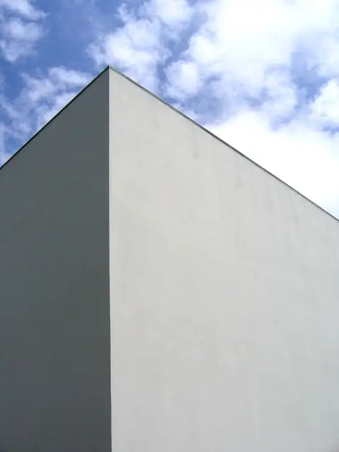 Esquina branca do edifício do Museu de Serralves recortada contra o céu azul com nuvens
