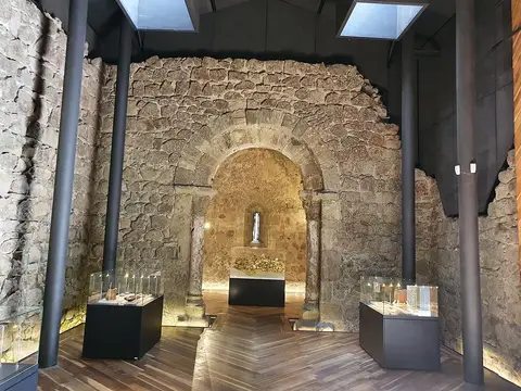 Interior musealizado da Igreja de São Pedro de Penaferrim, com arco em pedra e vitrinas de exposição