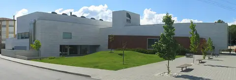 Exterior moderno da Biblioteca Municipal, com fachada clara, relvado e árvores jovens