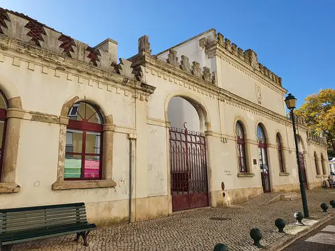 Fachada da Biblioteca Municipal de Alenquer, edifício amarelo com ameias e portão de ferro