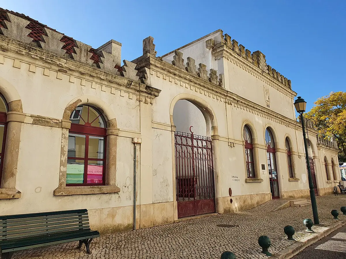 Fachada da Biblioteca Municipal de Alenquer, edifício amarelo com ameias e portão de ferro