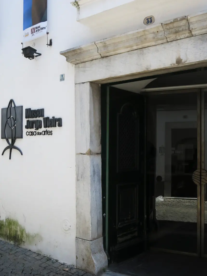 Entrada do Museu Jorge Vieira – Casa das Artes, em Beja, com porta de madeira e letreiro na fachada branca
