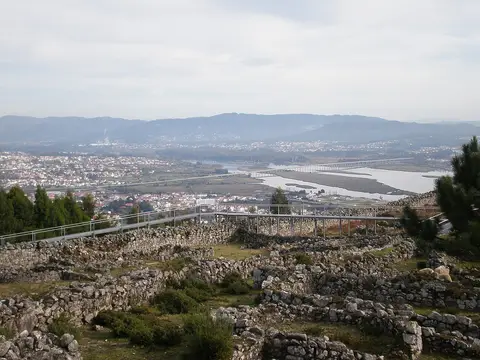 Ruínas circulares de pedra da Citânia de Santa Luzia com vista sobre o rio Lima e Viana do Castelo