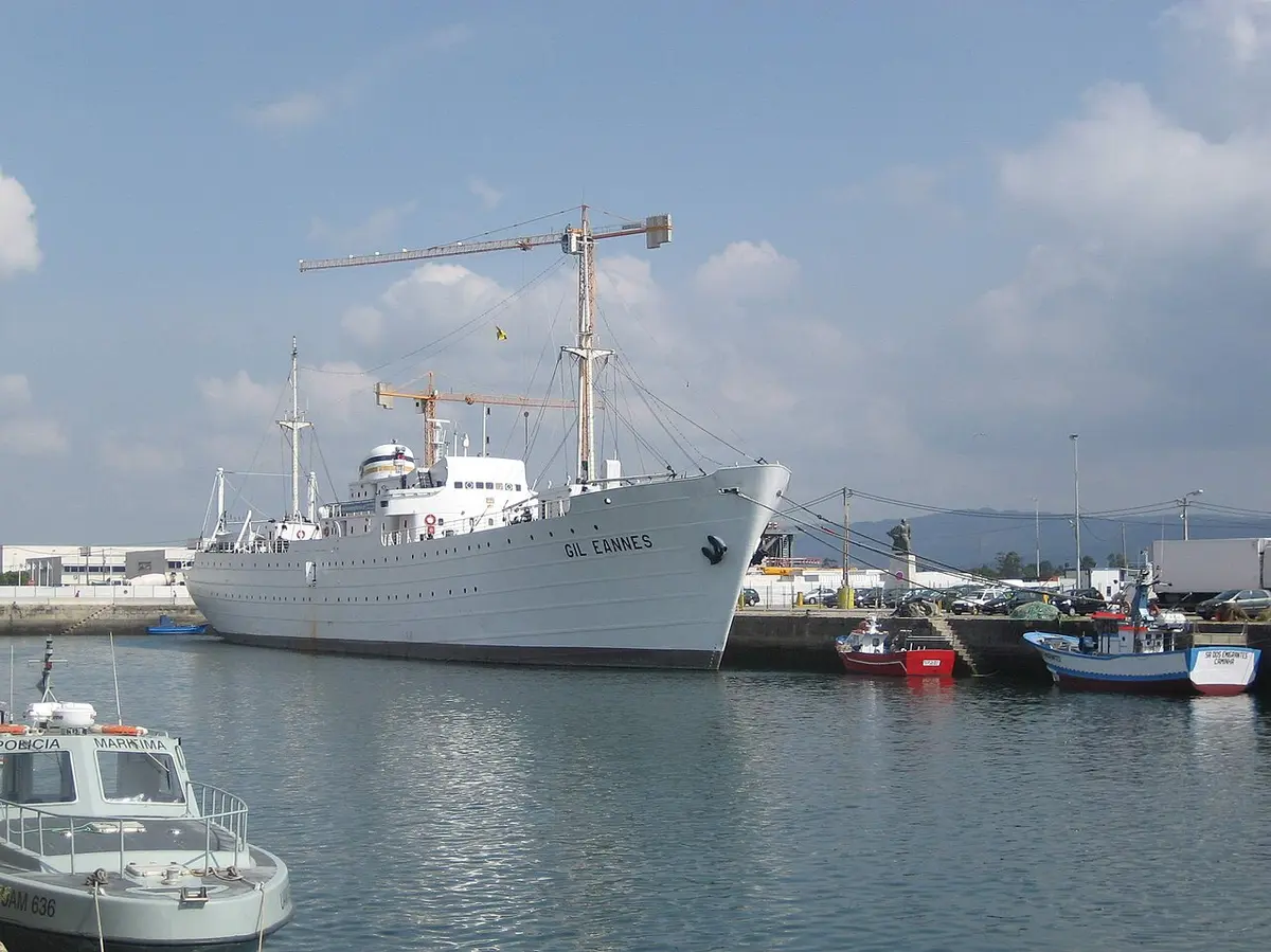 Navio-hospital Gil Eannes atracado no porto de Viana do Castelo, com barcos de pesca ao lado.