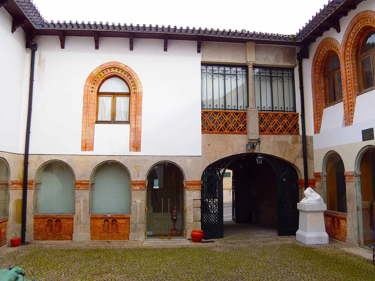 Pátio interior da Casa-Museu Teixeira Lopes, com arcadas, varanda e calçada portuguesa