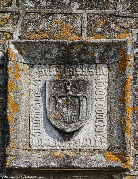 Pedra de armas gravada em granito com líquenes na fachada do Solar dos Pinheiros, Barcelos