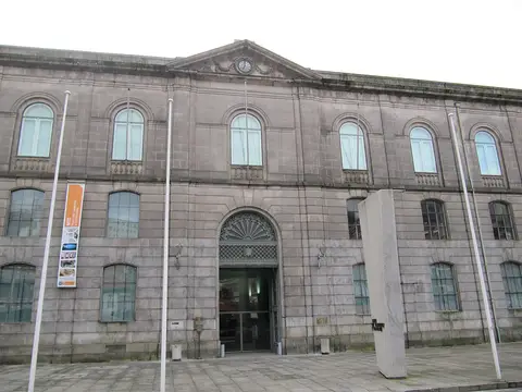 Fachada em pedra do Museu dos Transportes e Comunicações, no Porto, com entrada central em arco