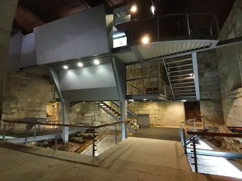 Interior da Casa do Infante com passadiços metálicos, escadaria e vestígios arqueológicos musealizados