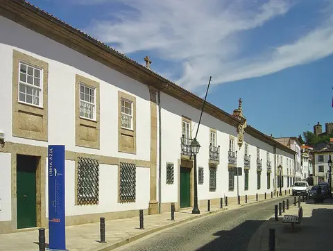 Fachada branca e comprida do Museu do Abade de Baçal, em rua calcetada de Bragança.