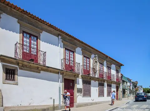 Fachada branca com varandas de ferro e portas vermelhas do Museu Municipal da Póvoa de Varzim