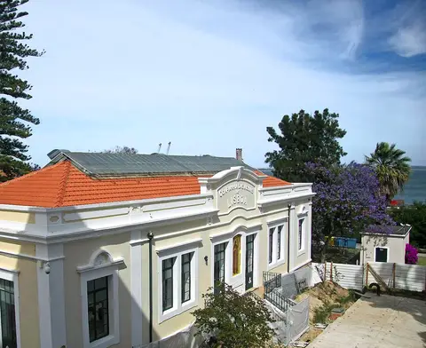 Edifício do Museu da Água, com fachada clara e telhado de telha, junto ao rio em Lisboa