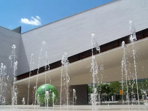 Fachada do Pavilhão do Conhecimento com repuxos de água e esfera verde em primeiro plano
