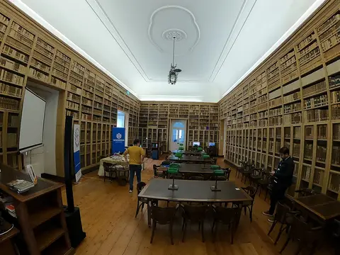 Sala de leitura da Biblioteca Pública de Évora, com estantes de madeira cheias de livros e mesas de consulta