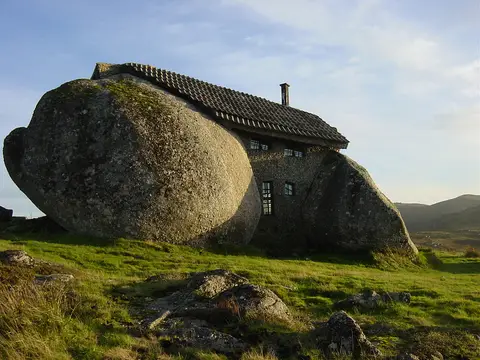 Casa do Penedo, construída entre grandes rochas de granito, numa encosta verde da serra em Fafe