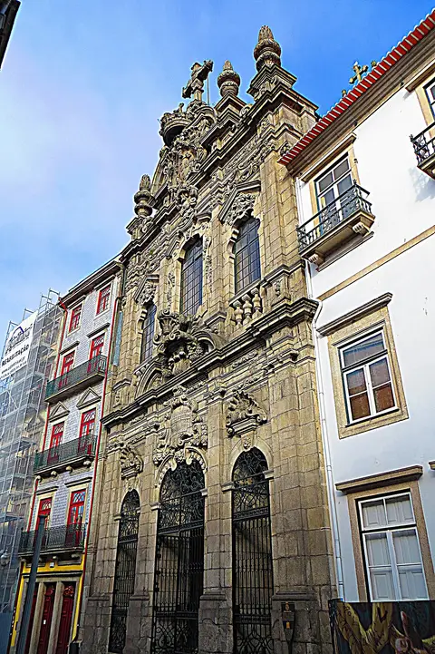 Fachada barroca em pedra da Igreja da Misericórdia do Porto, entre edifícios da rua