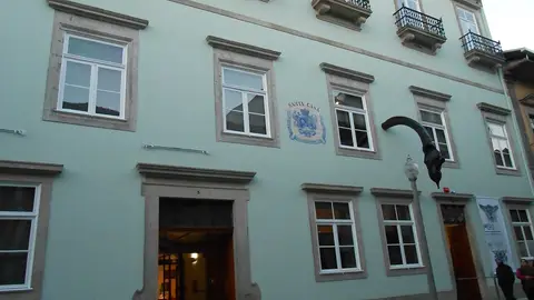 Fachada verde-clara do Museu da Misericórdia do Porto com painel de azulejos da Santa Casa