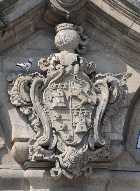 Brasão de pedra esculpido na fachada do Palácio do Raio, com pomba pousada