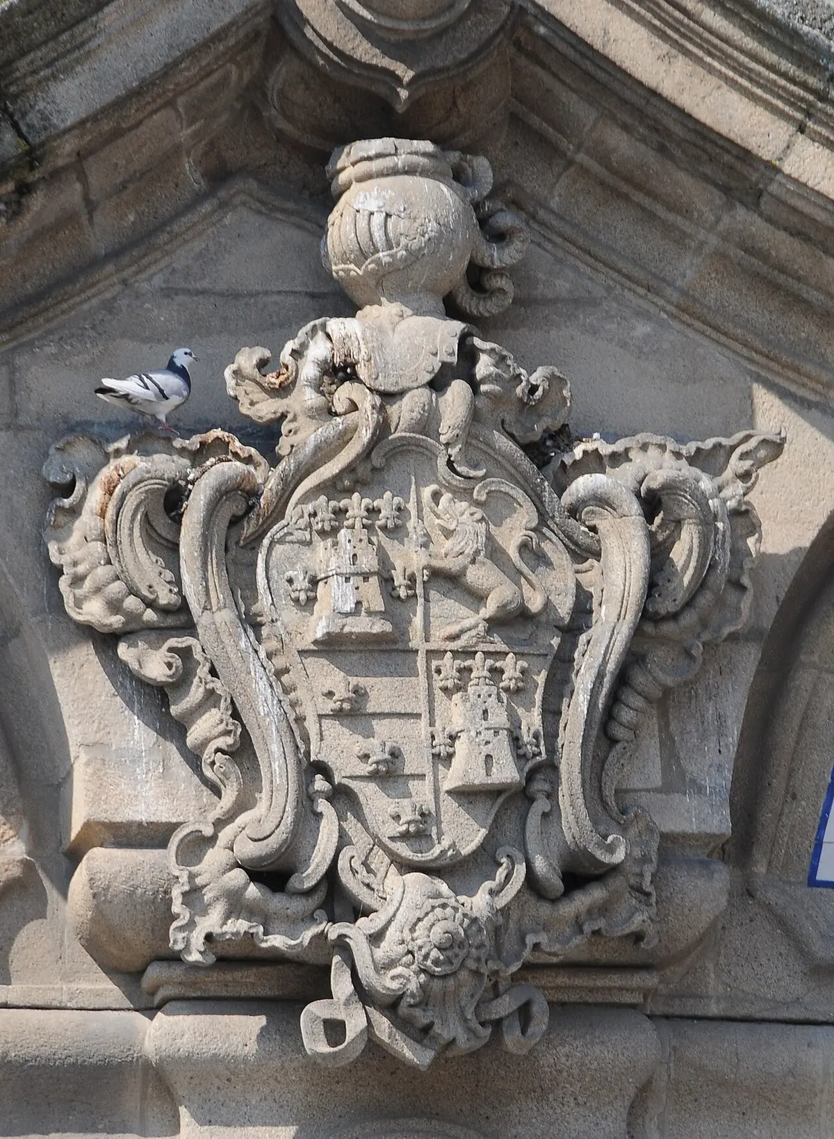 Brasão de pedra esculpido na fachada do Palácio do Raio, com pomba pousada