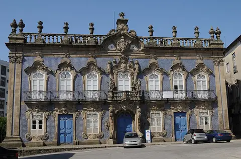 Fachada barroca do Palácio do Raio, em Braga, revestida a azulejos azuis, com varandas de ferro forjado.