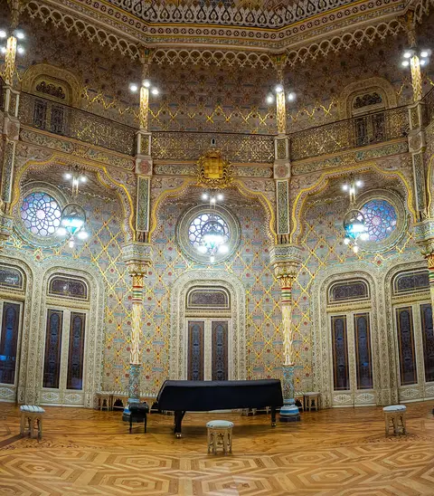 Salão Árabe do Palácio da Bolsa, no Porto, com decoração dourada e piano de cauda ao centro