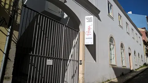 Entrada do Atelier-Museu Júlio Pomar, com portão de grades e letreiro vertical na fachada branca