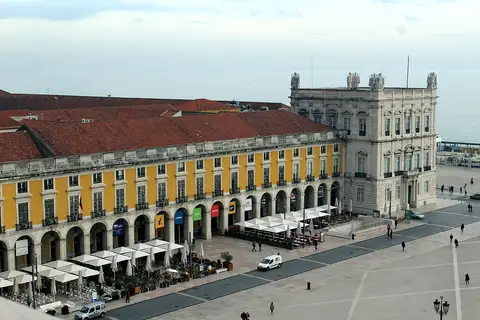 Vista elevada da Praça do Comércio, com os edifícios amarelos e arcadas onde se situa o Lisboa Story Centre