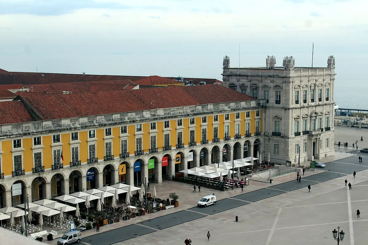 Vista elevada da Praça do Comércio, com os edifícios amarelos e arcadas onde se situa o Lisboa Story Centre