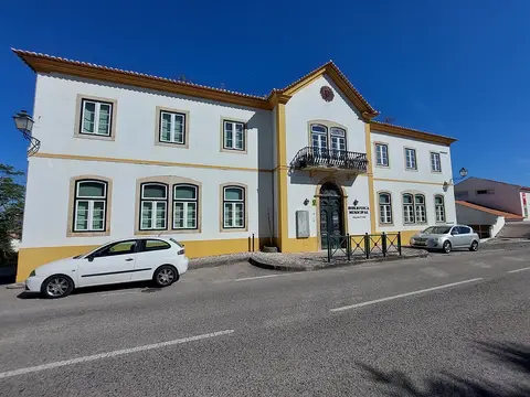 Edifício branco e amarelo da Biblioteca Municipal Alexandre O'Neill, em Constância, visto da rua.