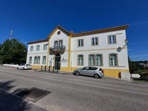 Edifício branco e amarelo da Biblioteca Municipal Alexandre O'Neill, em Constância, visto da rua