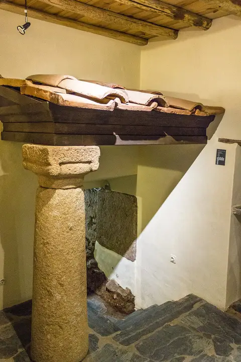 Interior do museu de Ammaia com reconstituição de telhado romano assente em coluna de granito.