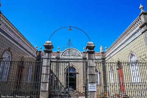 Fachada azulejada do Museu do Traje de São Brás de Alportel, vista do portão de ferro com letreiro