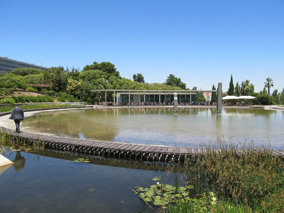 Lago do Jardim Amália Rodrigues em Lisboa, com passadiço de madeira e esplanada ao fundo