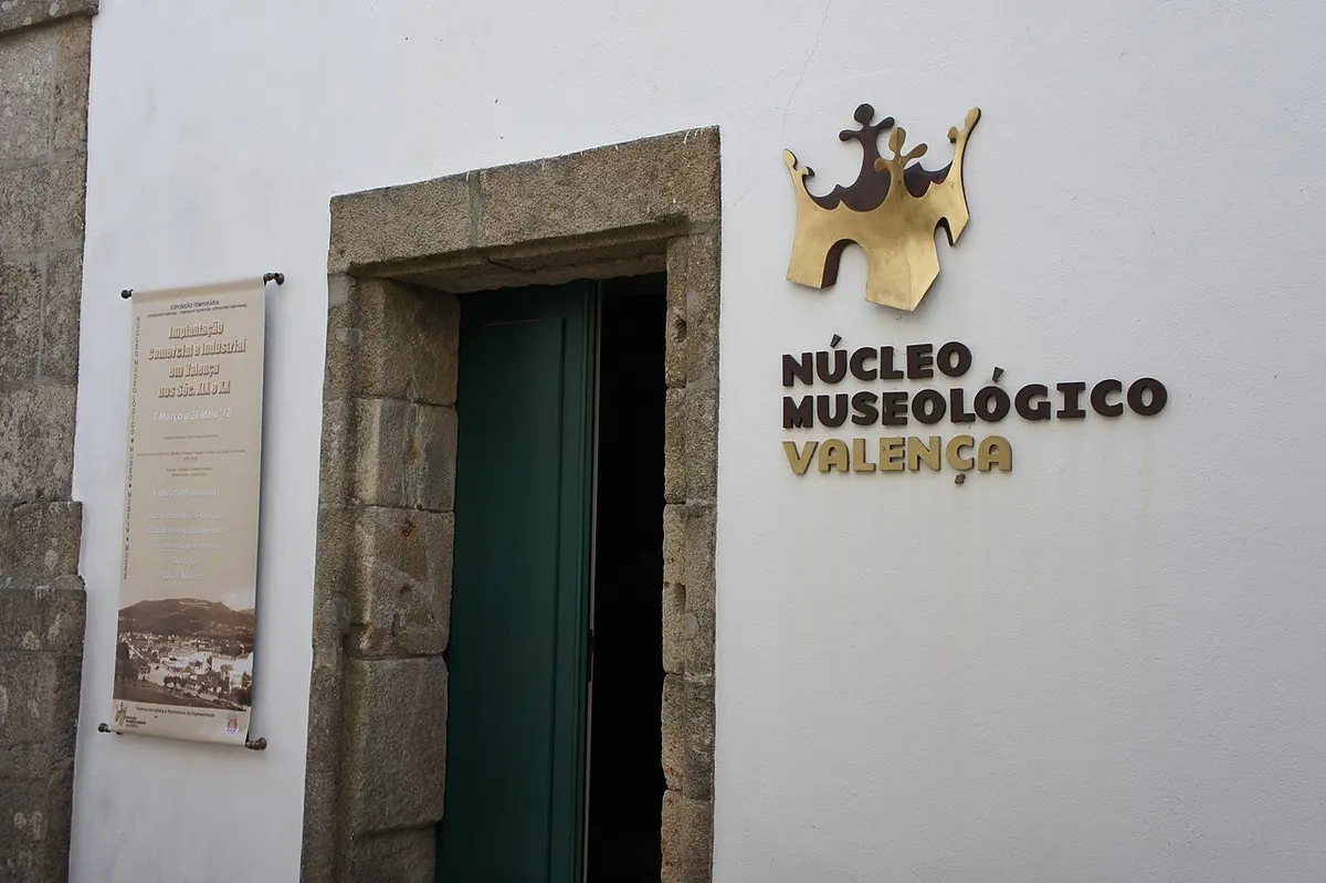 Entrada do Núcleo Museológico de Valença, com letreiro dourado na fachada branca e porta verde