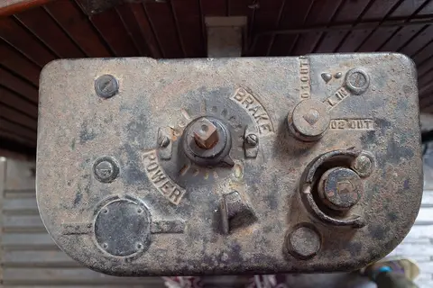 Comando antigo de carro eléctrico em metal, com indicações "POWER" e "BRAKE", no Museu do Carro Eléctrico