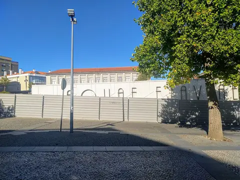 Vedação de obras com letreiro das Termas Romanas de Chaves e edifício ao fundo