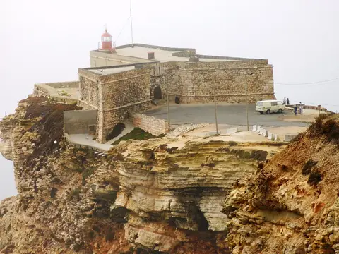 Forte de São Miguel Arcanjo com farol vermelho, sobre falésia rochosa na Nazaré
