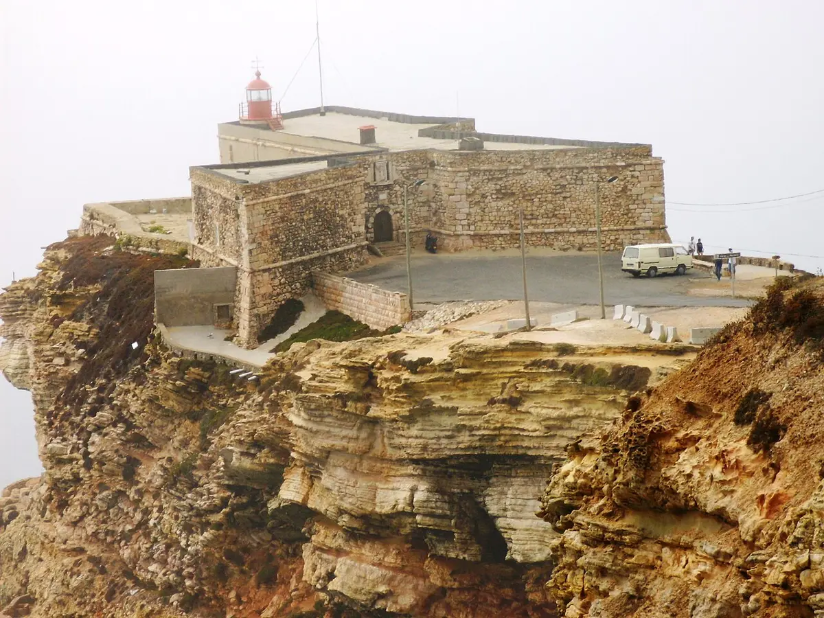 Forte de São Miguel Arcanjo com farol vermelho, sobre falésia rochosa na Nazaré