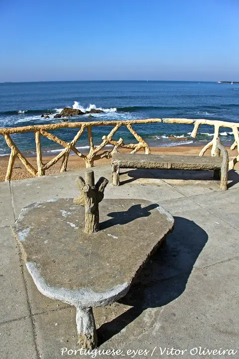 Miradouro com bancos de cimento imitando troncos sobre a Praia do Homem do Leme, no Porto