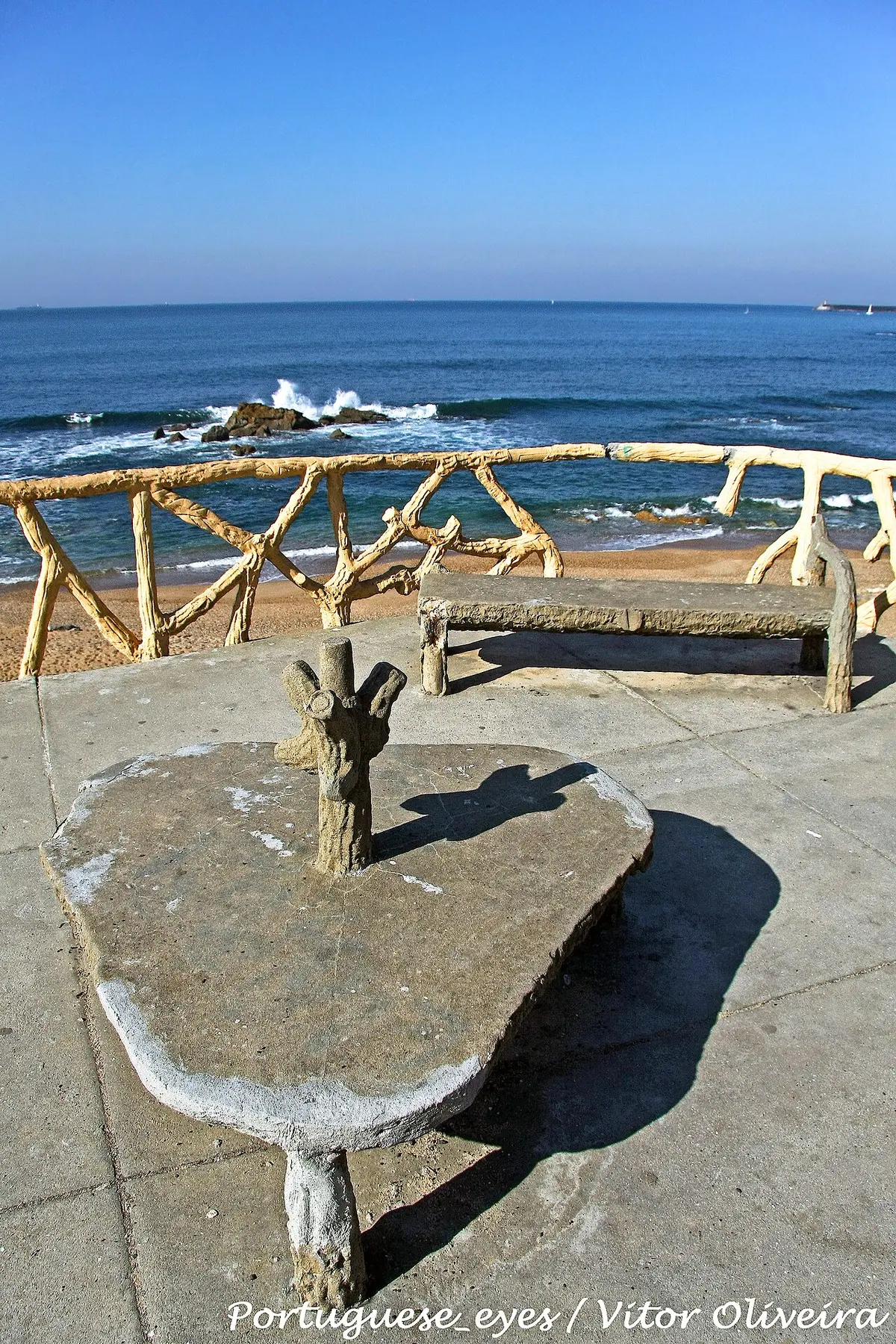 Miradouro com bancos de cimento imitando troncos sobre a Praia do Homem do Leme, no Porto