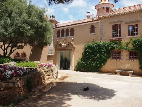 Fachada da Casa de Santa Maria, em Cascais, com portal em pedra, hera e canteiro florido